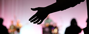 A student raises a hand in praise at chapel